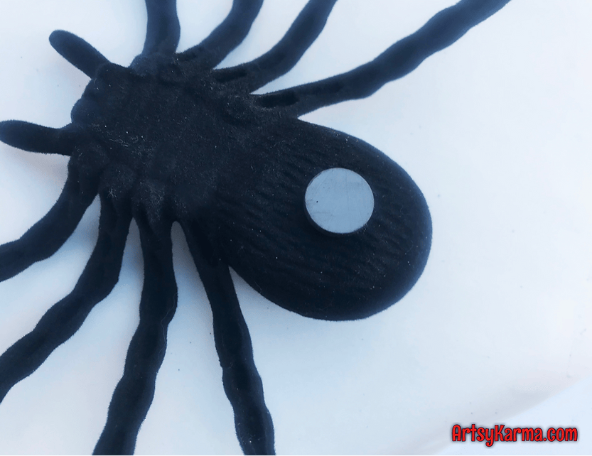 Glue magnets on spiders for spooky door decor