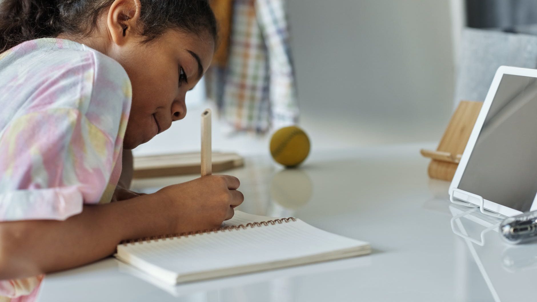 photo of girl writing on white paper