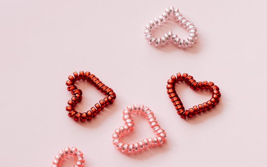 colorful coil hearts on pale pink background