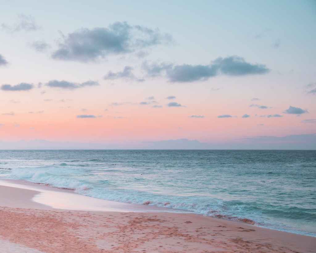 ocean waves crashing on shore during sunset