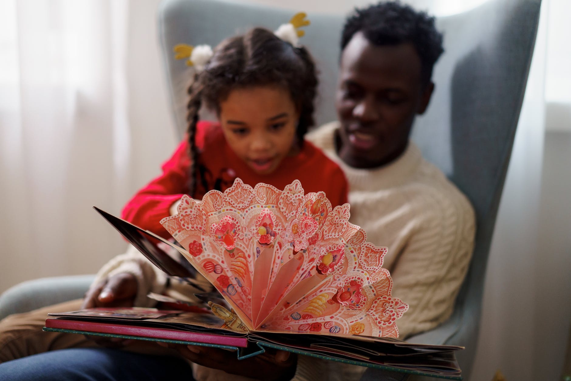 dad and daughter reading a cutouts fairy tale book