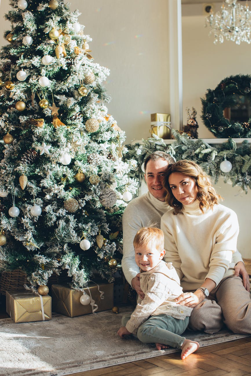 family sitting beside a christmas tree