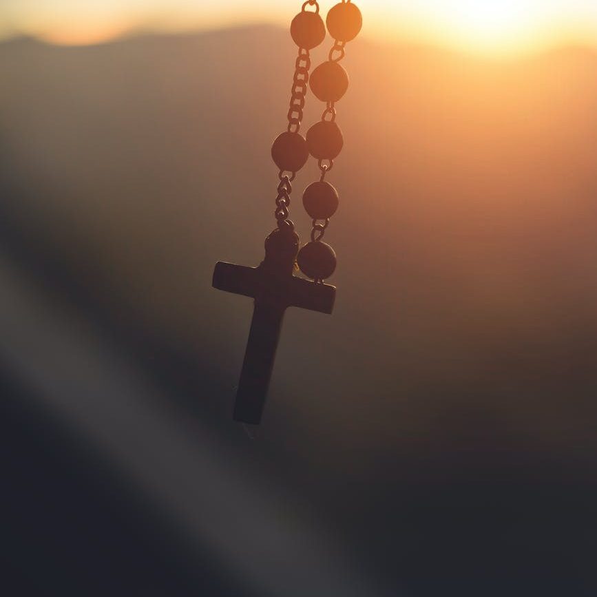 silhouette photography of hanging rosary