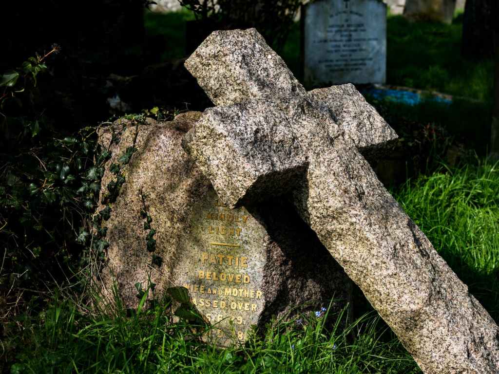 gray concrete cross on green grass field