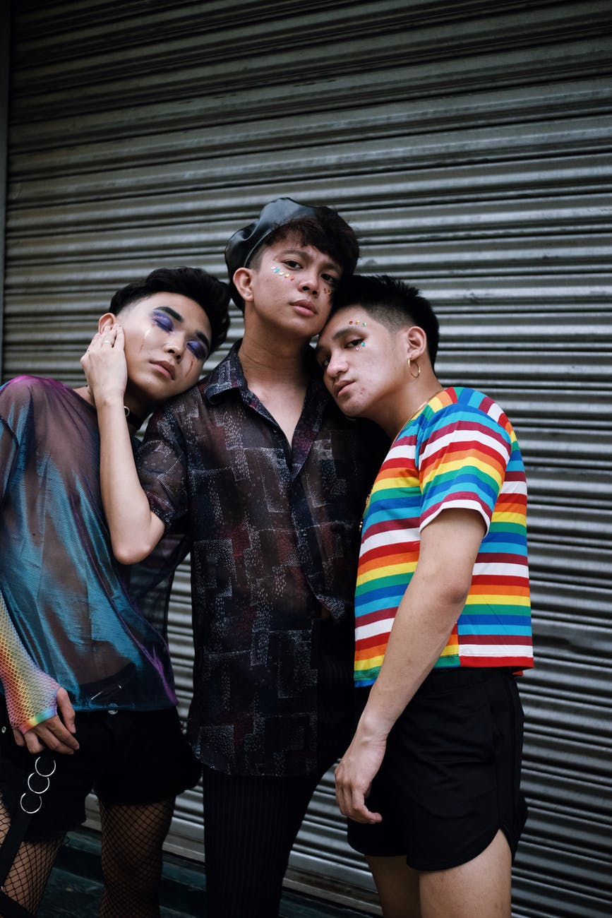 three men standing beside shutter door polyamorous