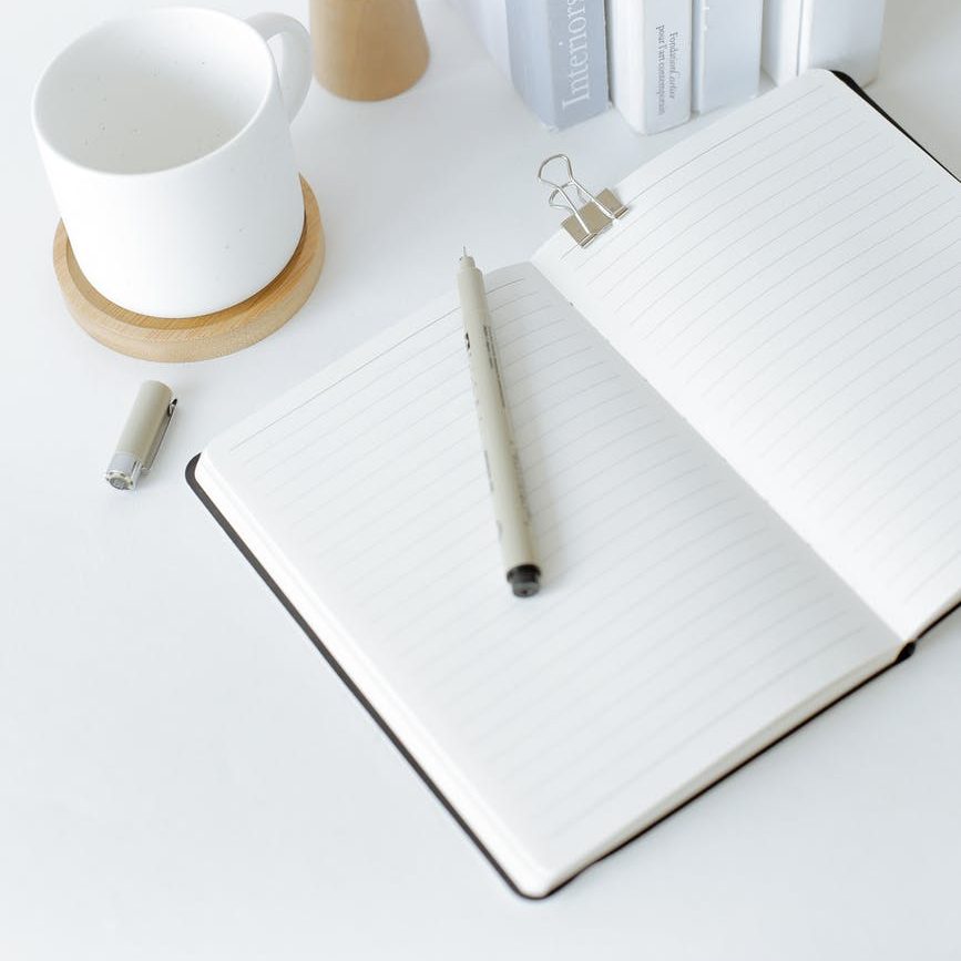 notebook opened on desk near books