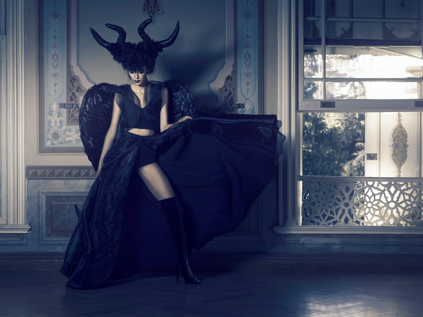 woman in black dress standing near window