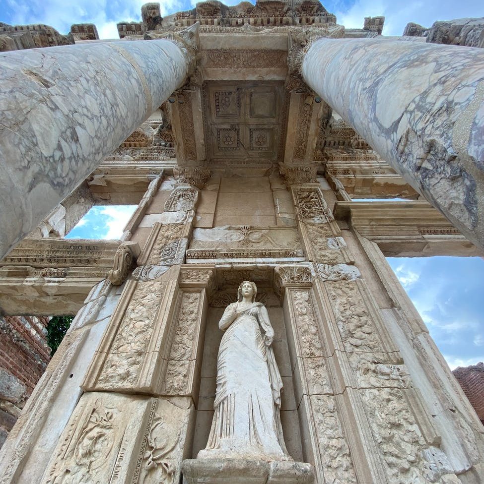 low angle photography of concrete building; goddess; god tempus