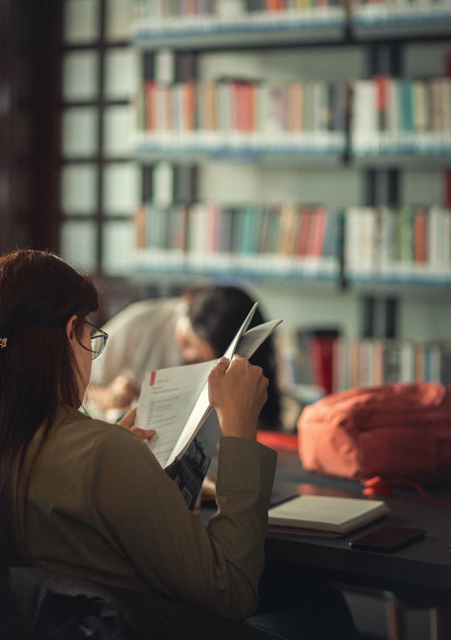 woman sitting and reading in library