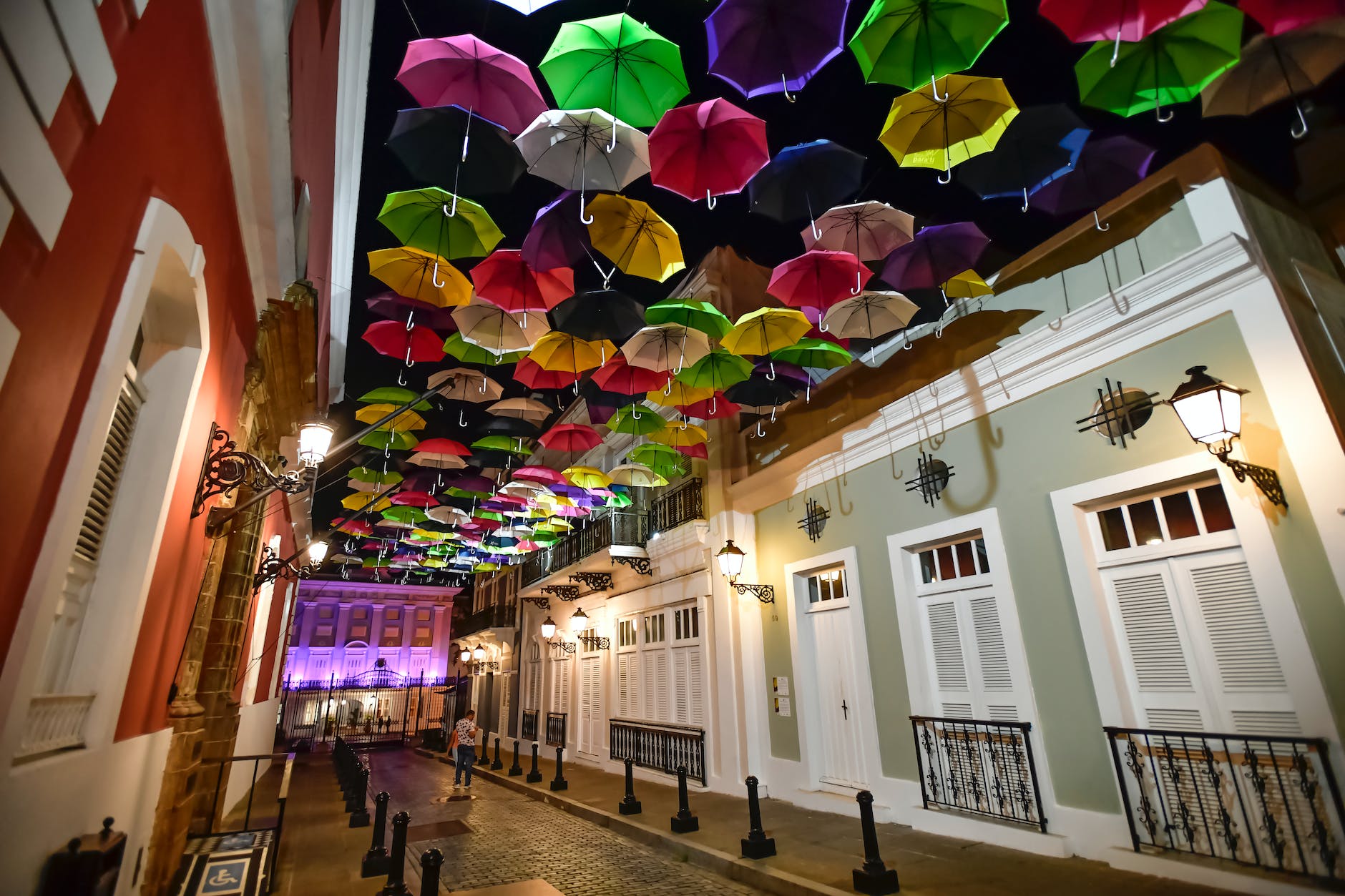 assorted coloured umbrellas hanging near buildings