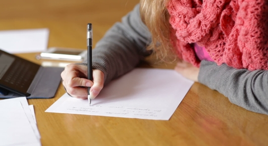 Woman writing on piece of paper