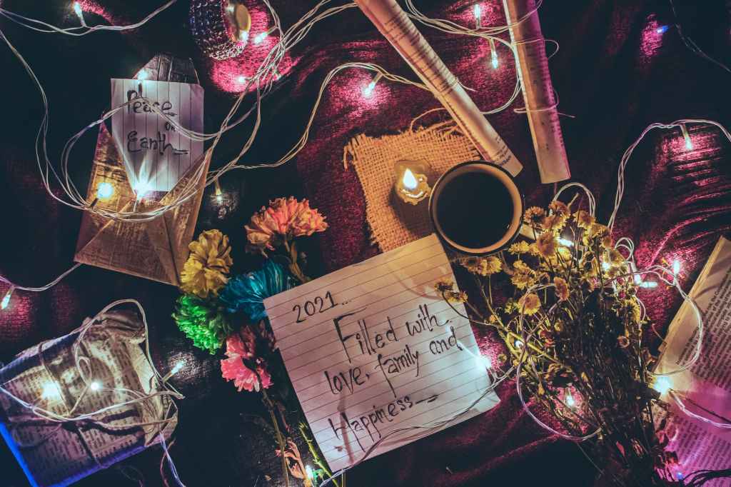 various decorations with flowers and glowing garland arranged on table during christmas celebration