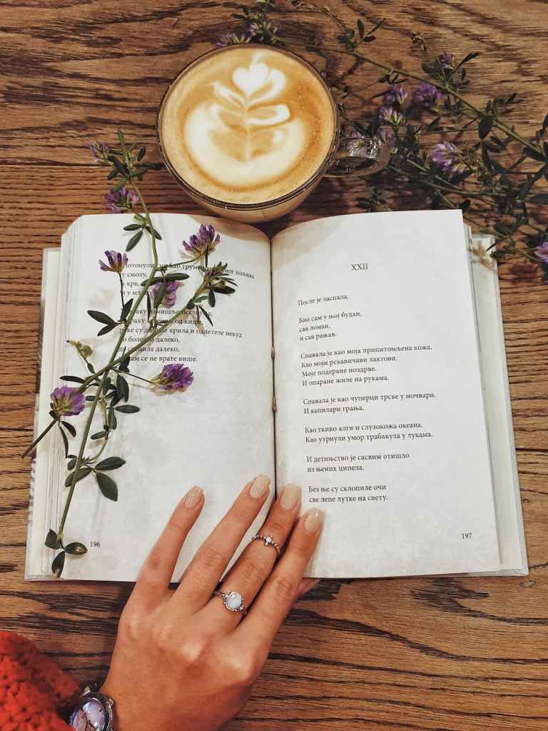beverage in cup next to open book; publishing