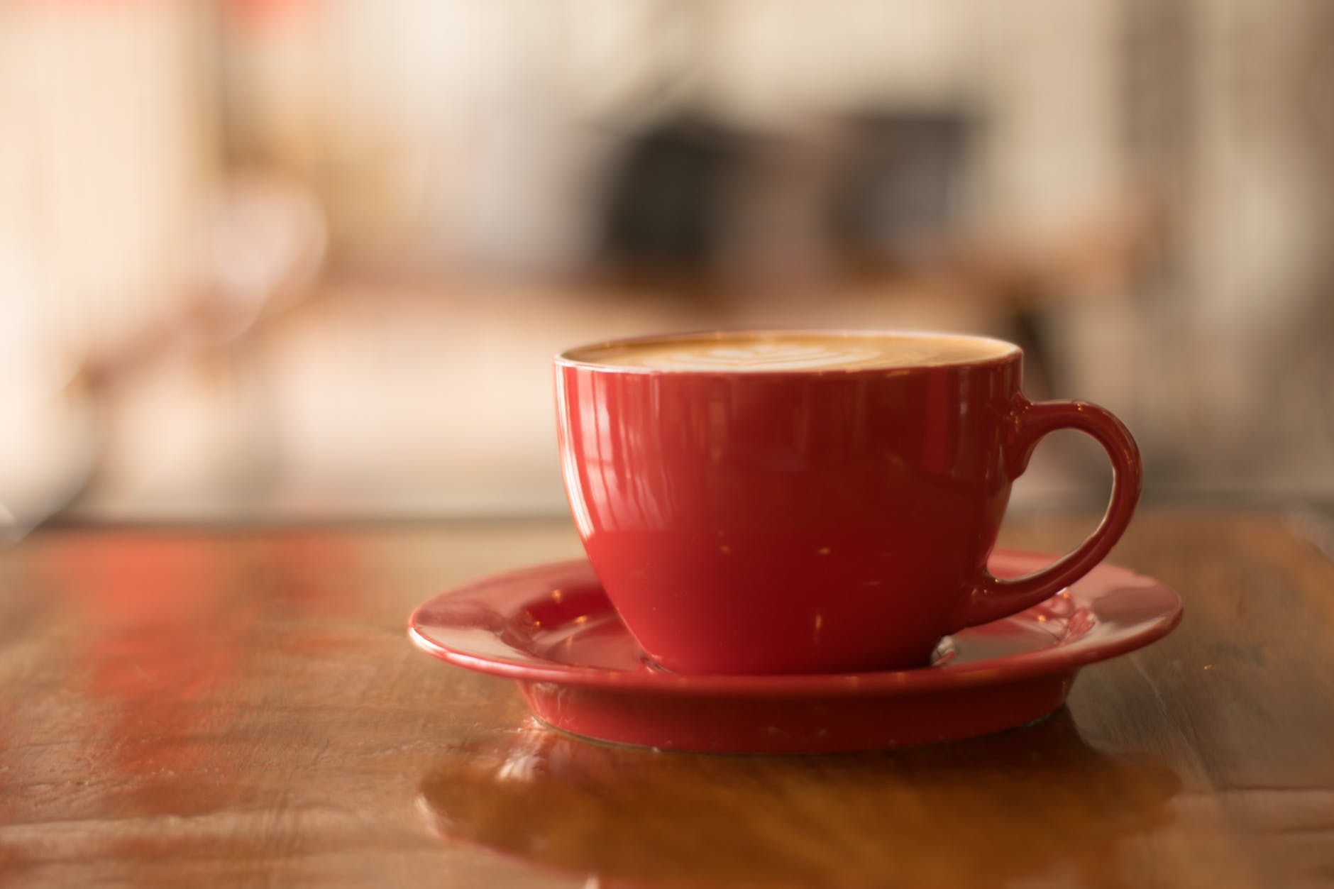red ceramic mug on red saucer