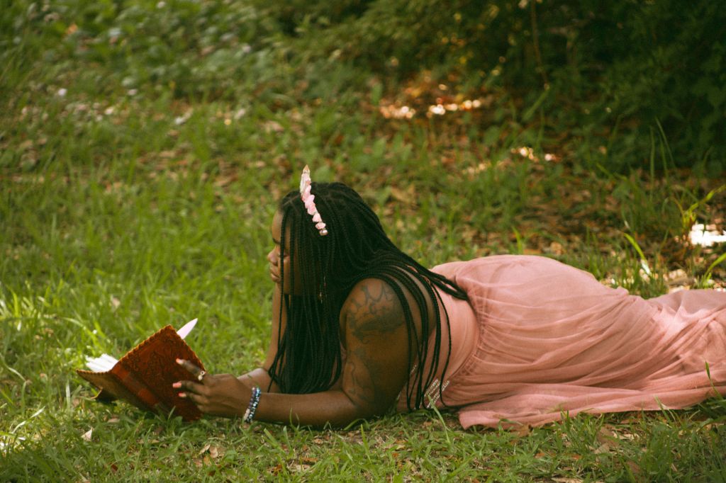Winnifred Tataw fairy pink laying down reading a book