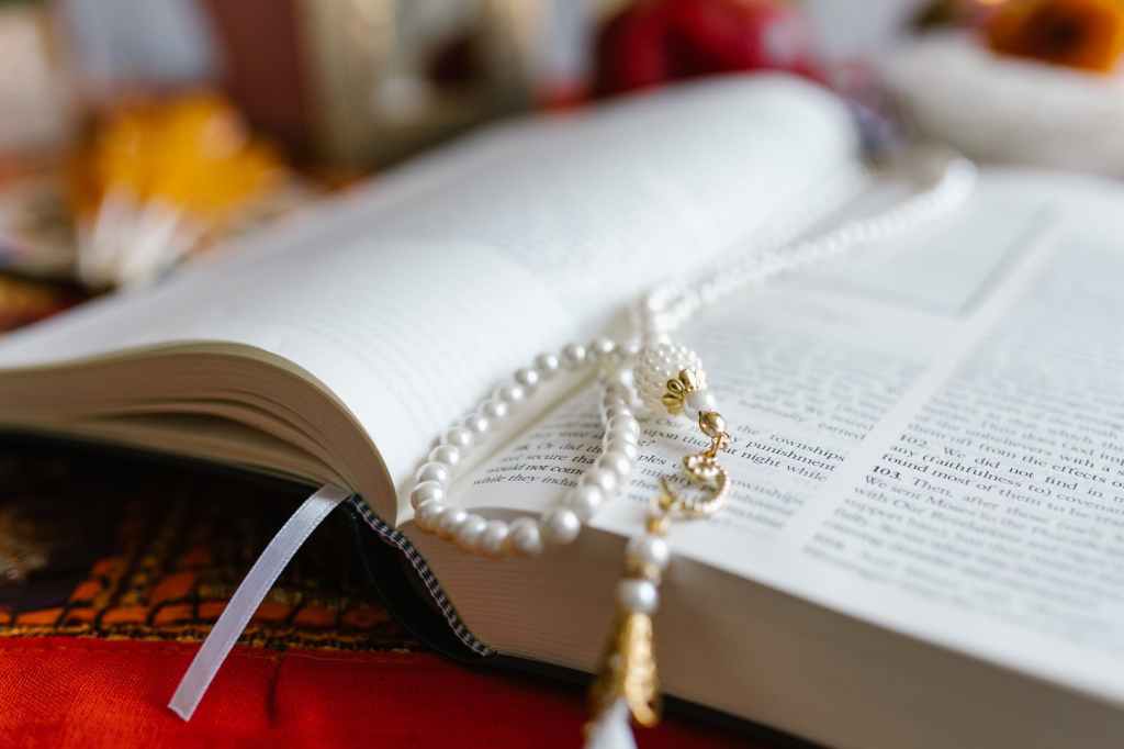 gold and silver beaded necklace on white book page
