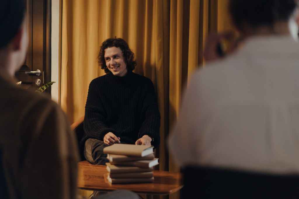 man in black sweater sitting on chair