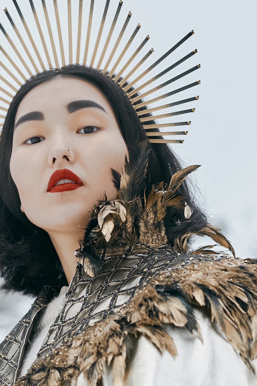 a woman wearing a crown and feathery cape