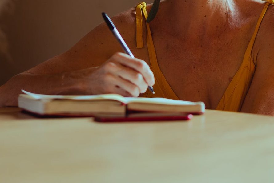 elderly woman writing her diary while smiling