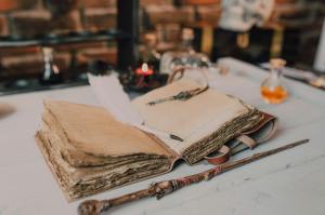 close up shot of a spell book and a wand