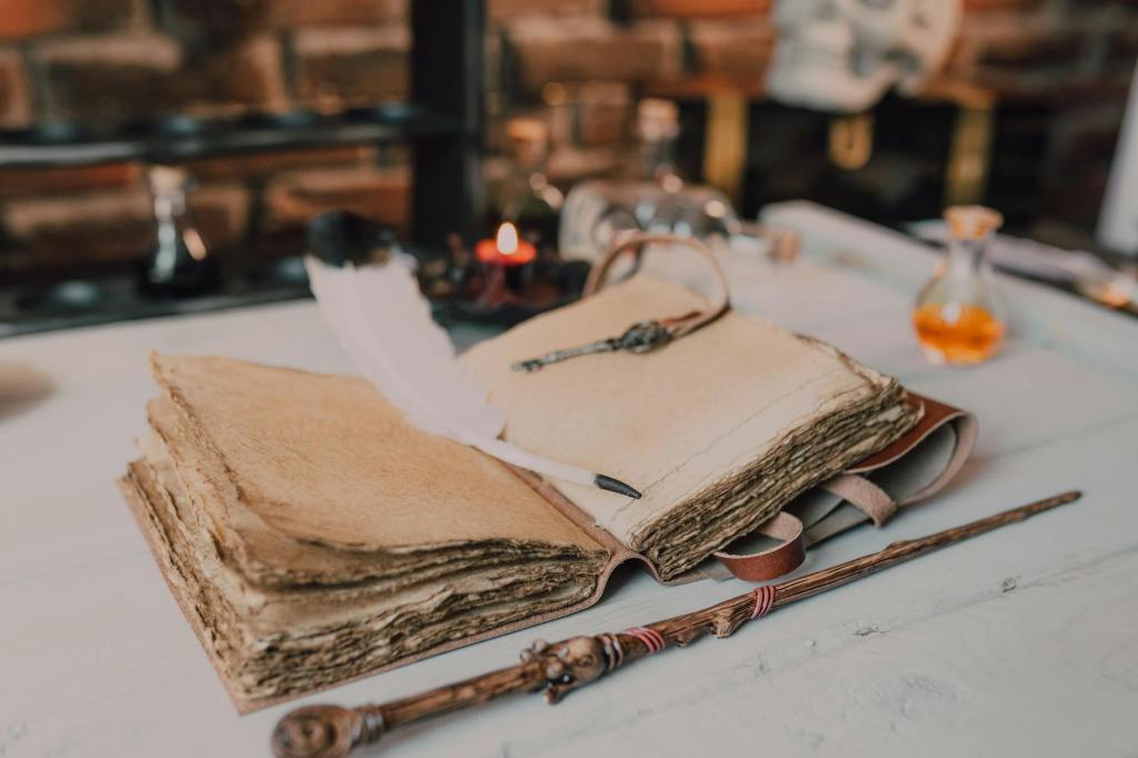 close up shot of a spell book and a wand