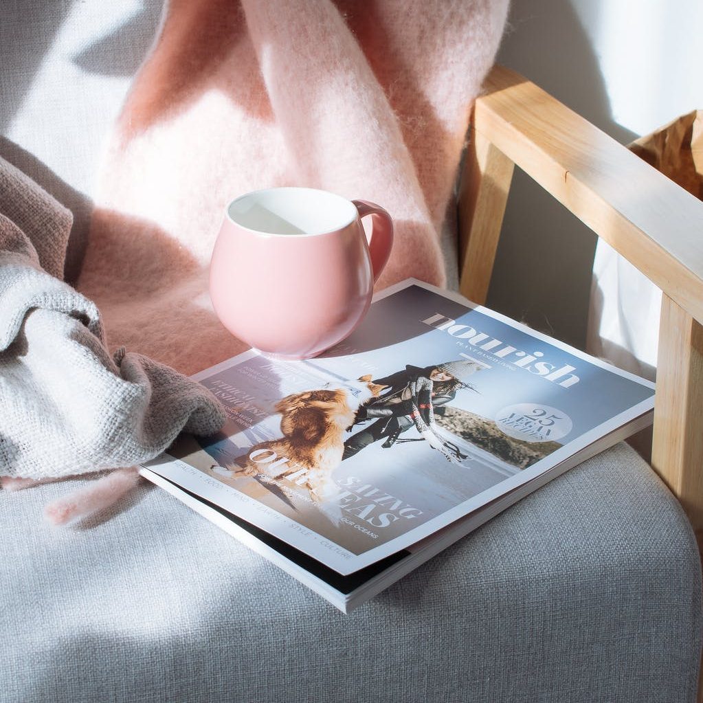 pink mug and magazine book