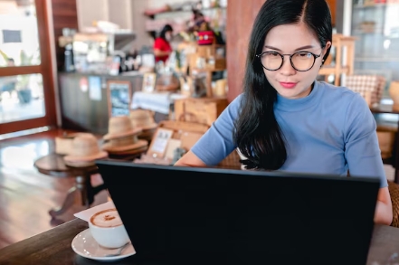 Woman looking at computer at a coffee shop