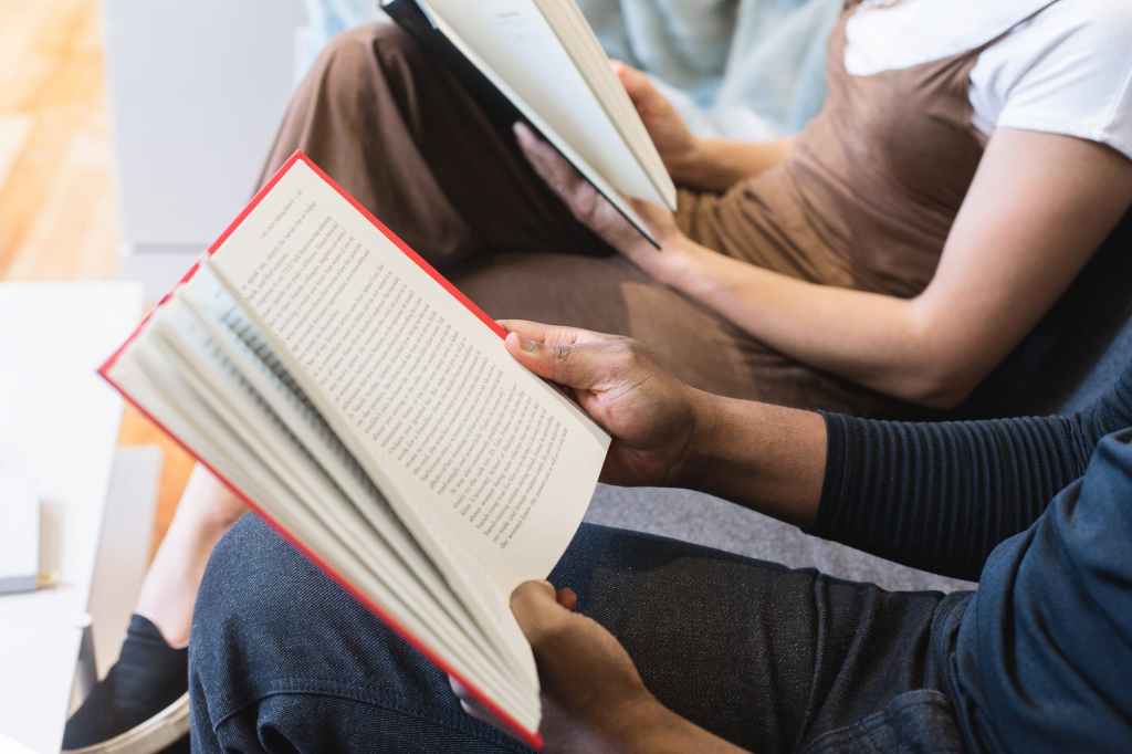 man reading book beside woman reading book