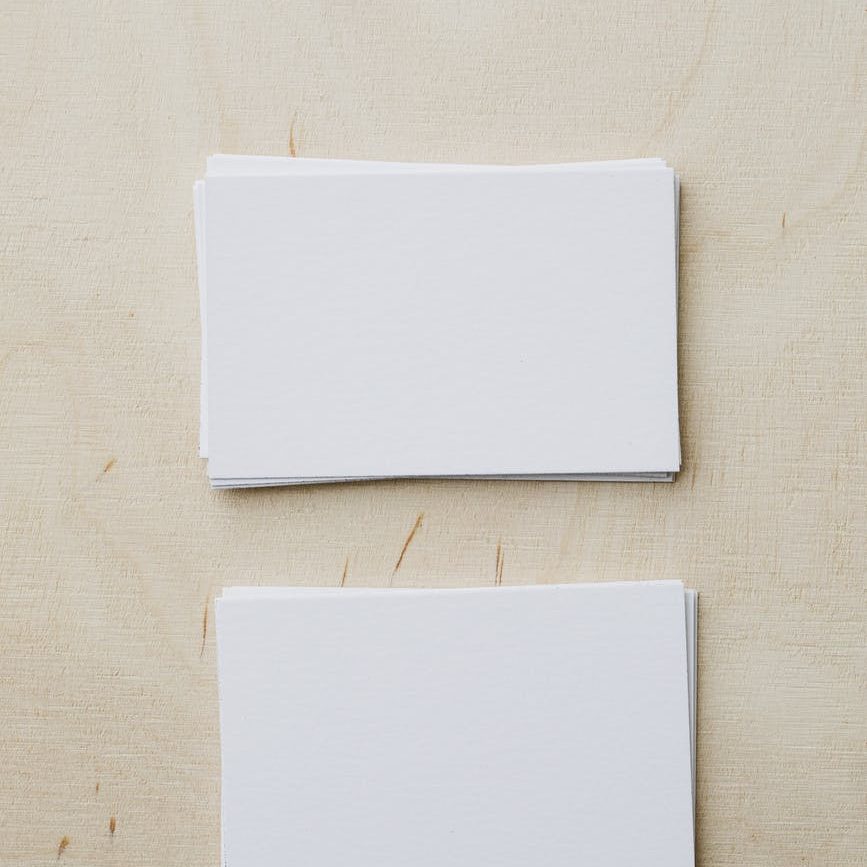 stacks of blank white visiting cards on table