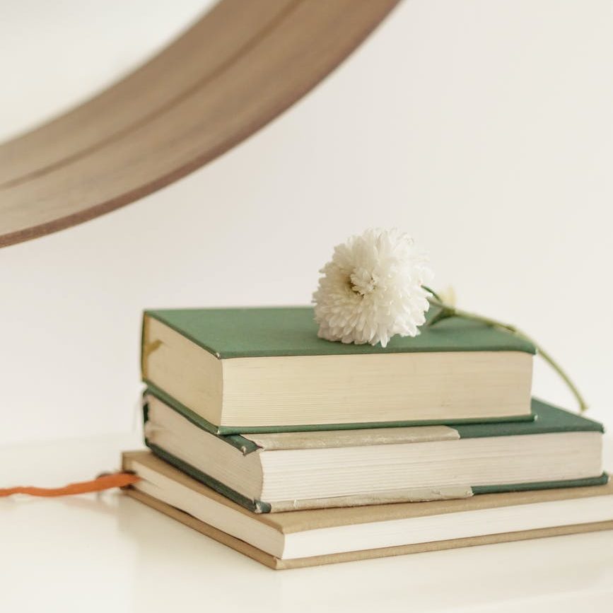 chrysanthemum on pile of books on table