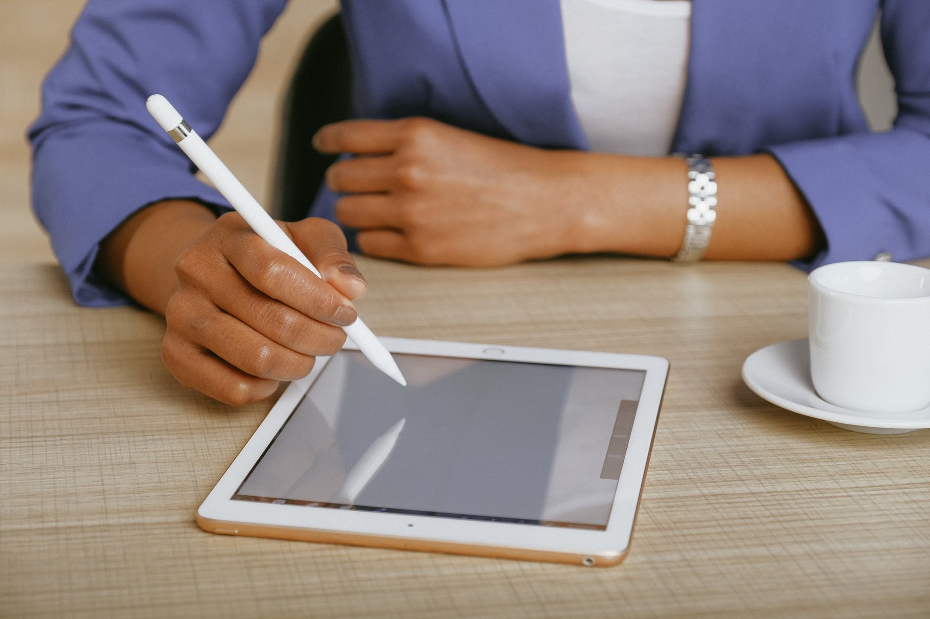 close up of woman using digital tablet to write; author spotlight with Winnie Tataw